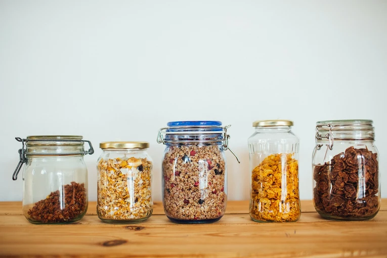 5 glass jars are kept on the brown table showing environment friendly packaging. By using these glass jars we can keep our environment clean